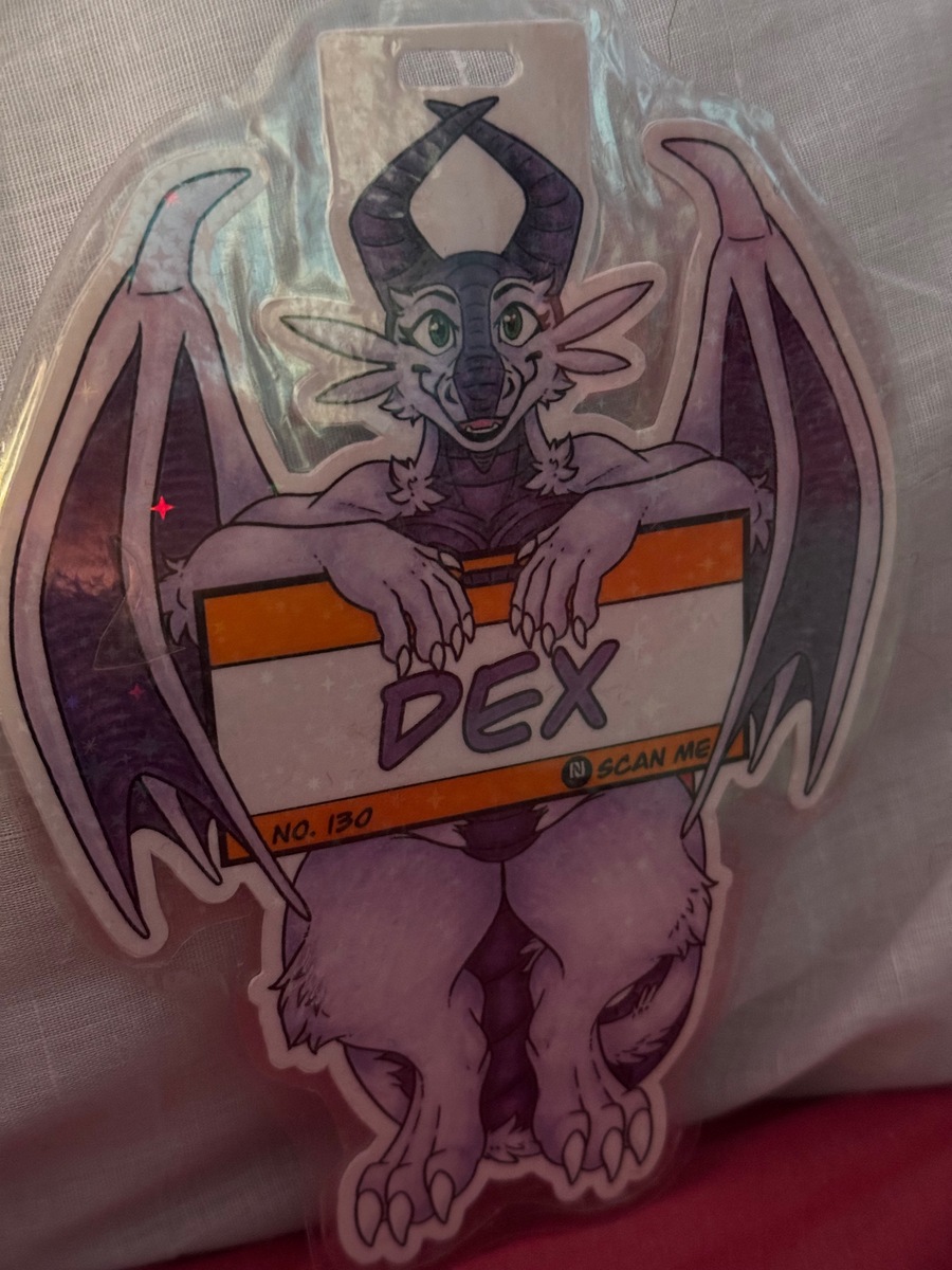 'Dangle Badge - Front' by kerijiano - September 2025
A glittery badge featuring a dragon holding on to a sign. A glittery badge featuring a dragon holding on to a sign.