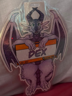 A glittery badge featuring a dragon holding on to a sign.